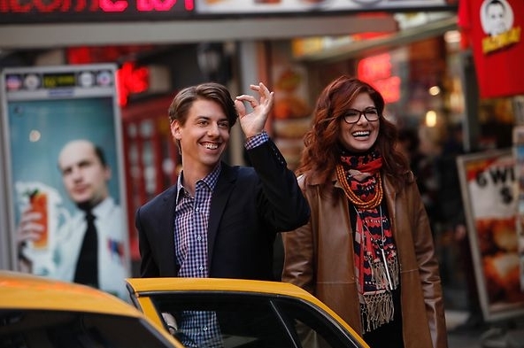Tom Levitt (Christian Borle) et Julia Houston (Debra Messing) tout sourire s'apprêtent à monter dans leur taxi